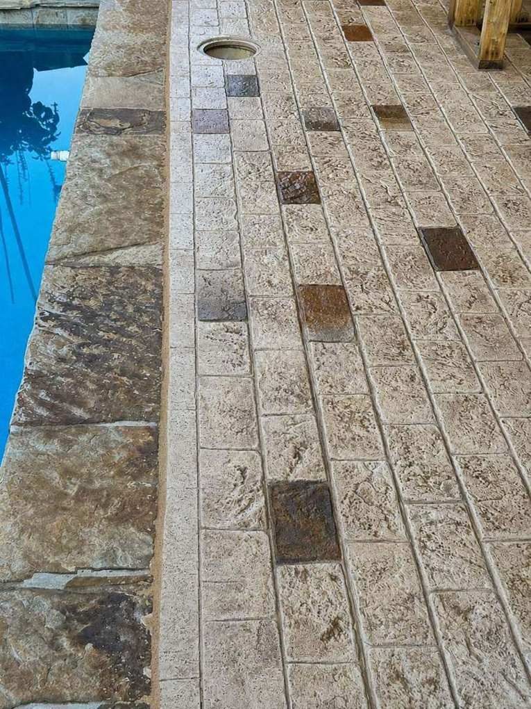 Cobblestone stamp-and-stain meeting the flagstone pool coping